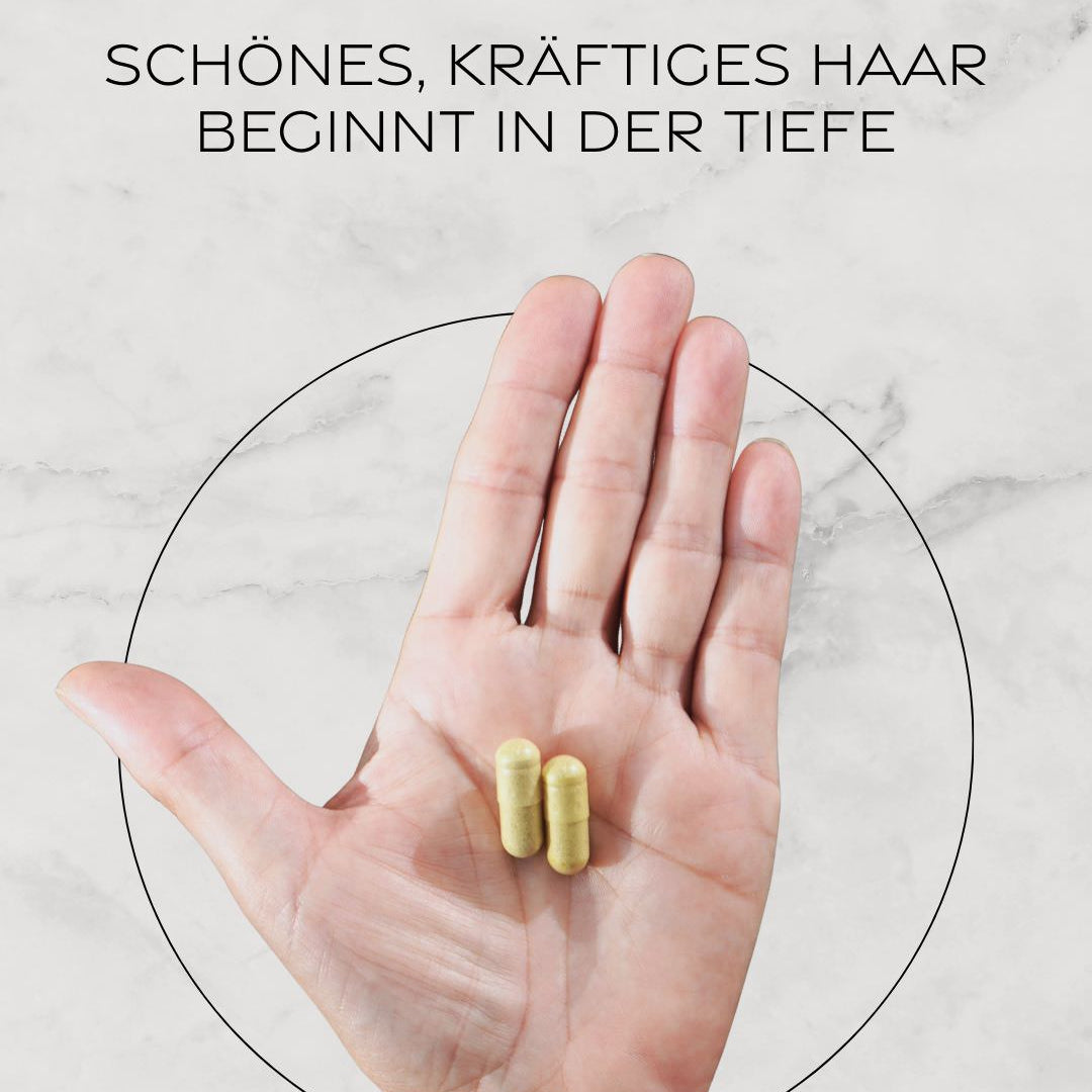 Hand mit zwei ONNI Hair Growth Vitamins Kapseln